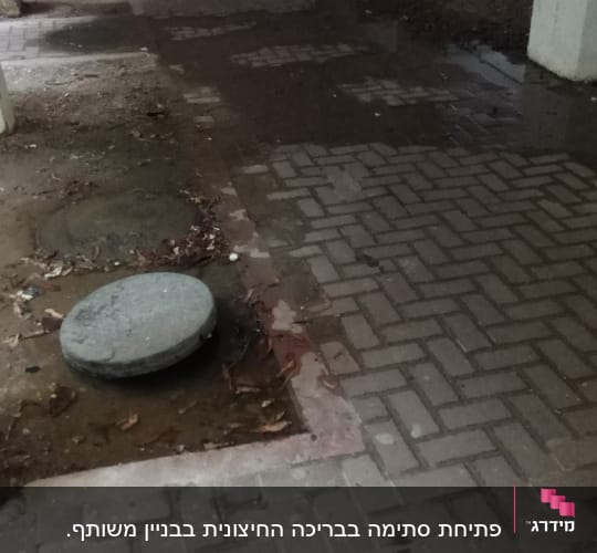 מכסה ביוב עגול על רצפת בטון רטובה